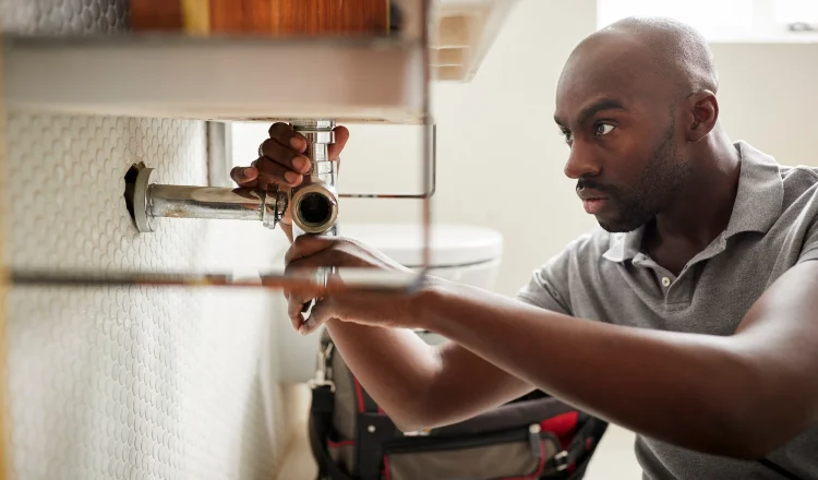 a male plumber fixing a pipe connection from The Leander Plumber - Company in Leander, TX - Plumber near me